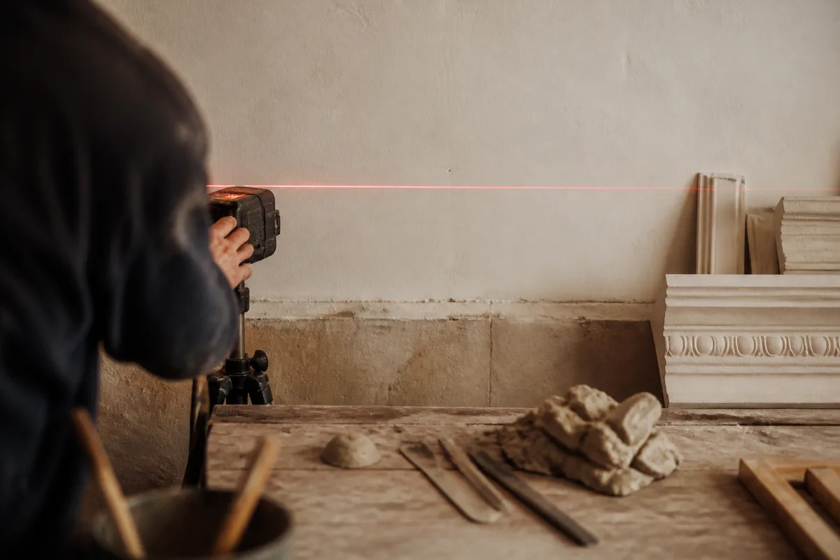 Tracé au laser d&rsquo;une ligne de référence sur un mur avant la pose d&rsquo;une corniche